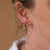 Ear close-up showing the Hawthorn Twig Small Hoop Earrings stacked with a larger hoop.