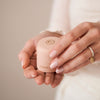 Thumbnail of Woman's hand holding a blush pink Chupi ring box.