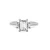 Thumbnail of Front view of the Hero Emerald Cut Three Stone Diamond Engagement Ring in 14k solid white gold, featuring a central 1.5ct emerald-cut diamond flanked by two smaller diamonds on a polished band.