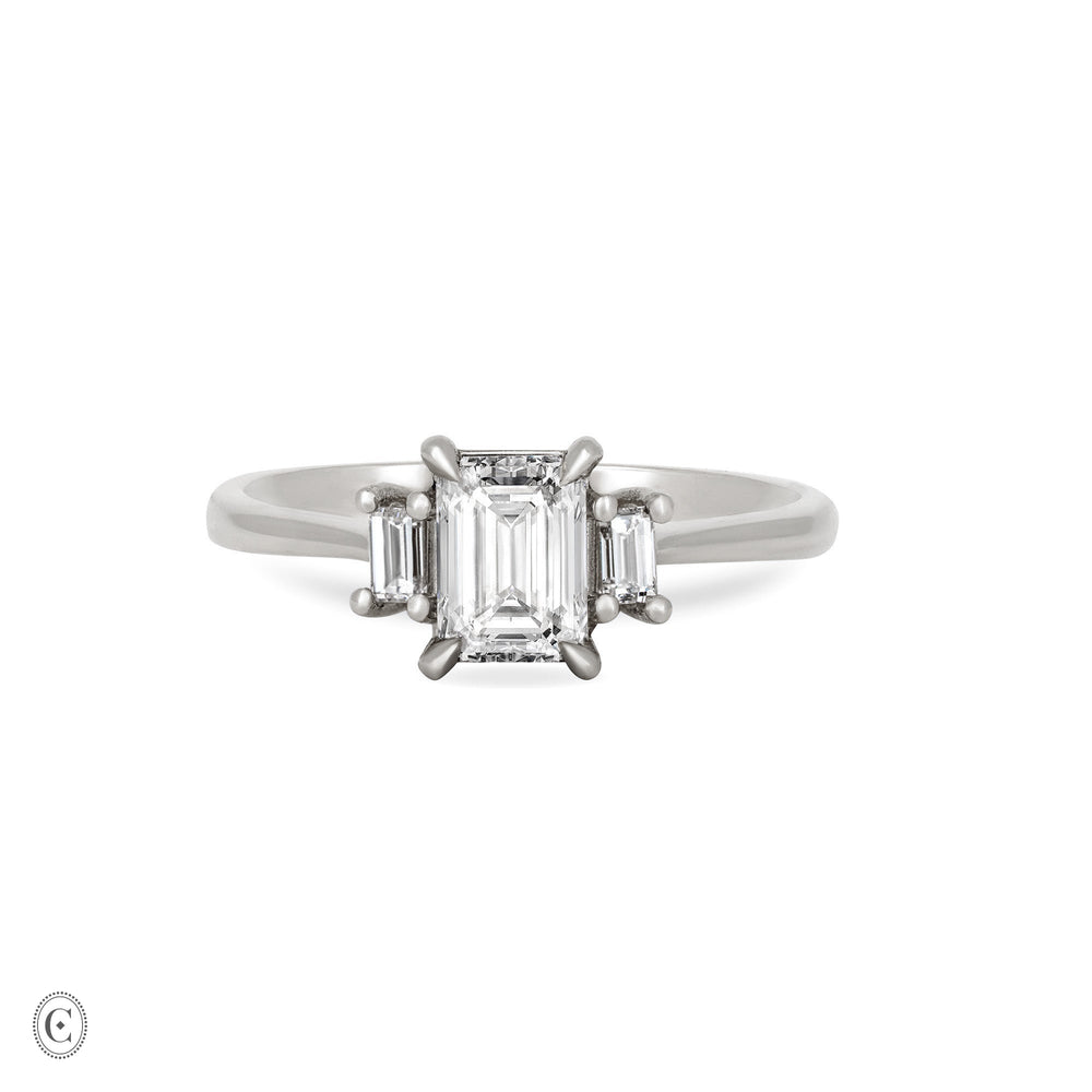 Front view of the Hero Emerald Cut Three Stone Diamond Engagement Ring in 14k solid white gold, featuring a central 1ct emerald-cut diamond flanked by two smaller diamonds on a polished band.