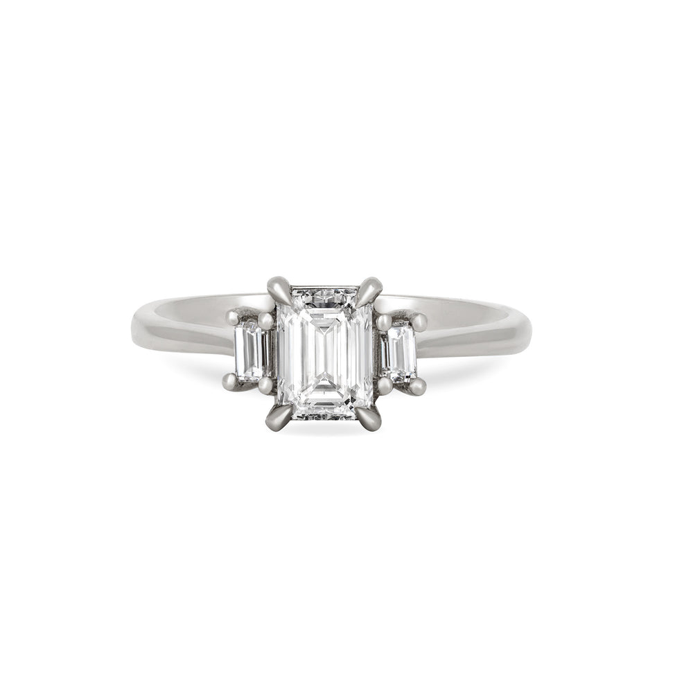 Front view of the Hero Emerald Cut Three Stone Diamond Engagement Ring in 14k solid white gold, featuring a central 1ct emerald-cut diamond flanked by two smaller diamonds on a polished band.