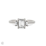 Front view of the Hero Emerald Cut Three Stone Diamond Engagement Ring in 14k solid white gold, featuring a central 1ct emerald-cut diamond flanked by two smaller diamonds on a polished band.