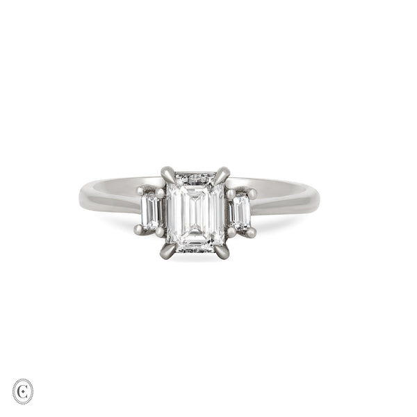 Front view of the Hero Emerald Cut Three Stone Diamond Engagement Ring in 14k solid white gold, featuring a central 1ct emerald-cut diamond flanked by two smaller diamonds on a polished band.