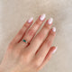 Close-up of a hand wearing the Daydreamer Marquise Emerald & Diamond Ring in 14k polished gold.