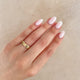 Close-up of a hand wearing the Driftwood 4mm Wedding Band in 14k gold.