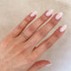 Close-up of a hand wearing the Follow Your Heart Diamond Wedding Ring in 14k gold on a twig band.
