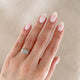 Close-up of a hand wearing the Guiding Light Trilogy Oval Diamond Engagement Ring in 14k solid gold, on a polished band.