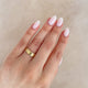 Close-up of a hand wearing the Hawthorn Bark Wide Wedding Band in 14k polished gold.