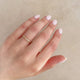 Close-up of a hand wearing the Hawthorn Twig Ring in 14k gold.