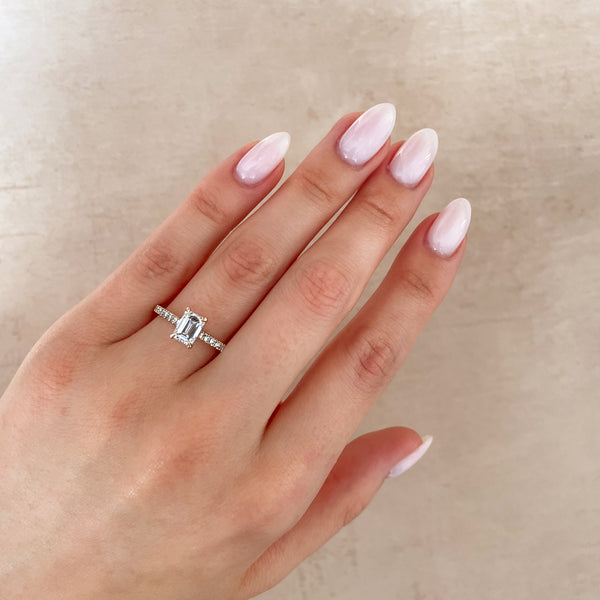 Alternative view of Close-up of hand wearing Chupi Heritage emerald cut diamond engagement ring with eternity band in 14k gold, perfect for proposals.