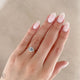 Close-up of a hand wearing the Hero Emerald Cut Three Stone Diamond Engagement Ring in 14k white gold.