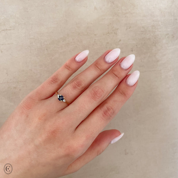 Alternative view of Close-up of a hand wearing the Love is All Blue Sapphire Engagement Ring in 14k white gold, on a polished band.