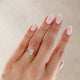 Close-up of a hand wearing the Moonlight Oval Diamond Engagement Ring in 14k solid gold, on a polished band.