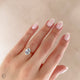 Close-up of a hand wearing the Moonlight Oval Diamond Engagement Ring in 14k solid gold, on a twig band.
