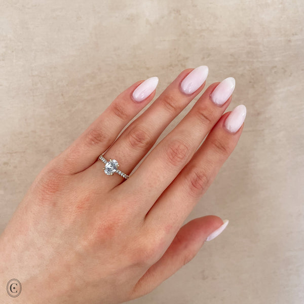 Alternative view of Close-up of a hand wearing the Moonlight Eternity Oval Diamond Engagement Ring in 14k solid gold.