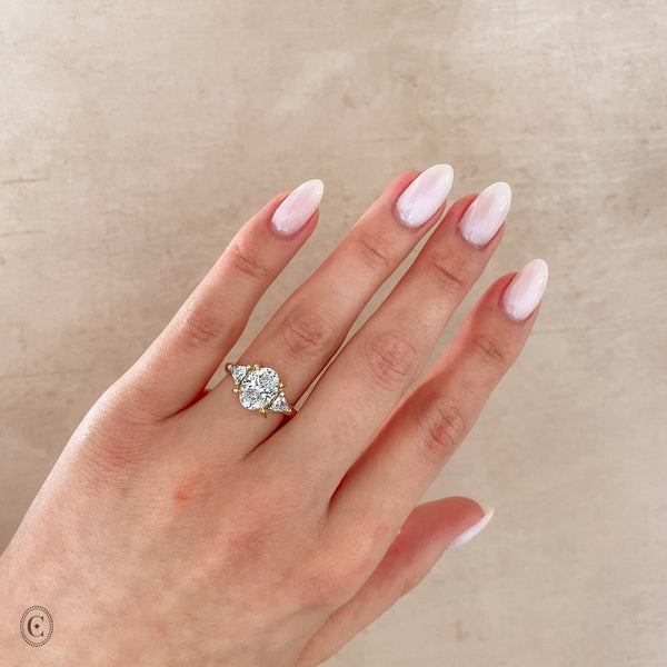 Alternative view of Close-up of a hand wearing the One in a Trillion 2.4ct Lab-Grown Oval Diamond Engagement Ring in 14k gold with a twig band.