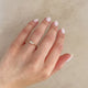 Close-up of a hand wearing the Promise Me Tomorrow Diamond Ring in 14k polished white gold.
