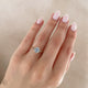 Close-up of a hand wearing the Starlight Oval Diamond Engagement Ring in 14k solid gold.