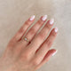 Close-up of a hand wearing the Sun, Moon & Stars Opal Ring in 14k solid gold.