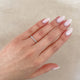 Close-up of a hand wearing the Tomorrow Diamond Eternity Ring in 14k polished gold.
