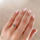 Close-up of a hand wearing the You, Me & Magic Grey Diamond Engagement Ring in 14k white gold, on a polished band.