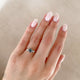 Close-up of a hand wearing the You, Me & Magic Grey Diamond Engagement Ring in 14k solid gold, on a twig band.