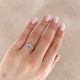 Close-up of a hand wearing the You, Me & Magic Round Cut Three Stone Engagement Ring in 14k solid gold, on a polished band.