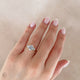 Close-up of a hand wearing the You, Me & Magic Round Cut Three Stone Engagement Ring in 14k solid gold, on a polished band.