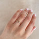 Close-up of a hand wearing the Yours & Mine 2mm Wedding Ring in 14k gold.