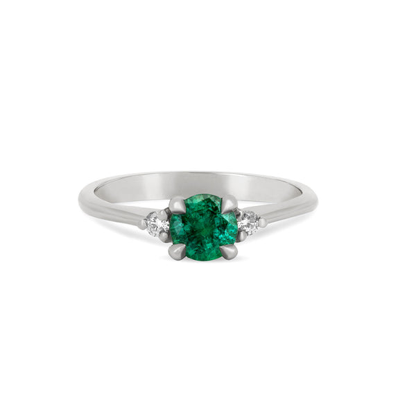 Front view of the Love is All Emerald Engagement Ring in 14k white gold, featuring a brilliant cut emerald on a polished band.