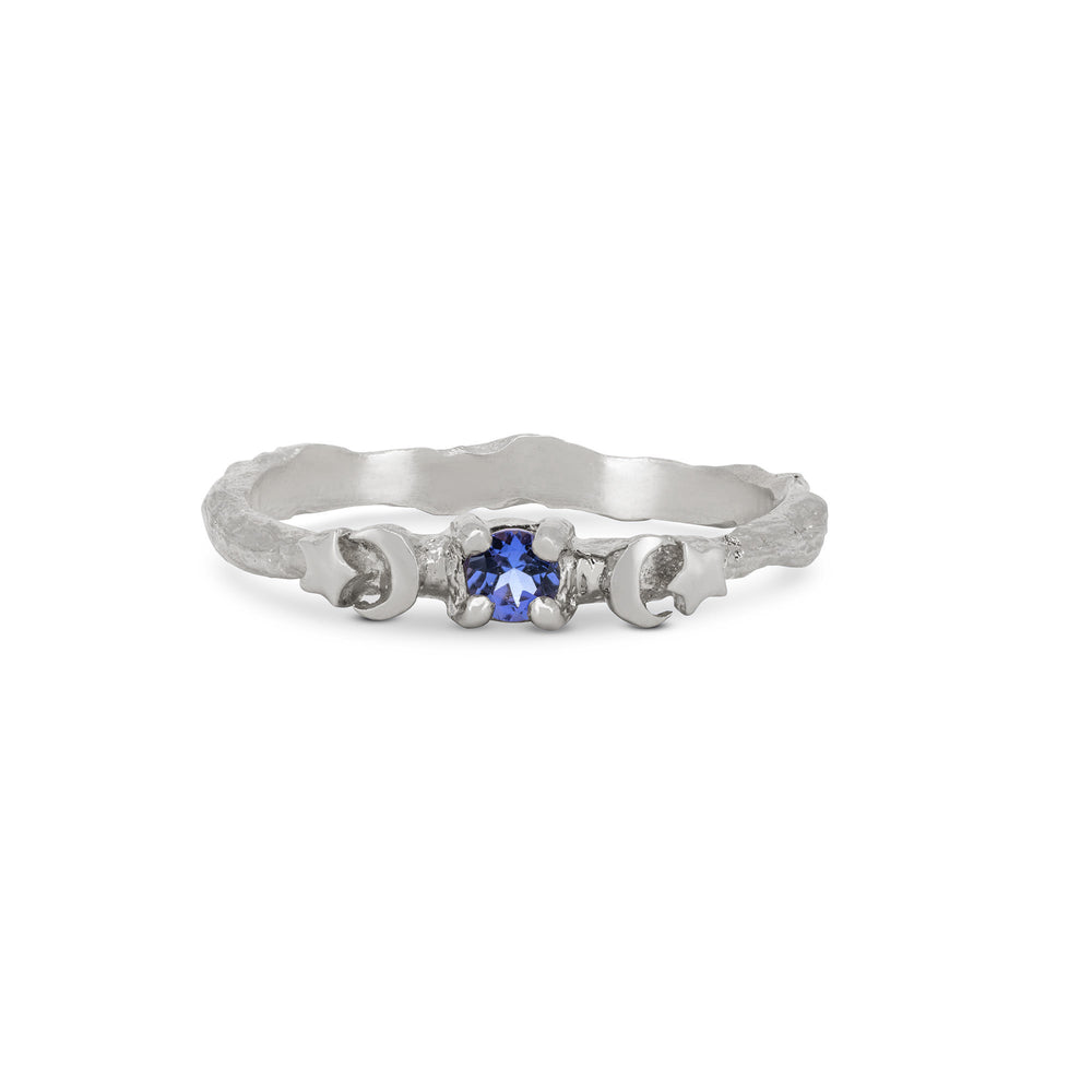 Front view of the Sun, Moon & Stars Tanzanite Ring in 14k white gold, featuring a round tanzanite stone flanked by sun, moon, and star motifs on a twig band.