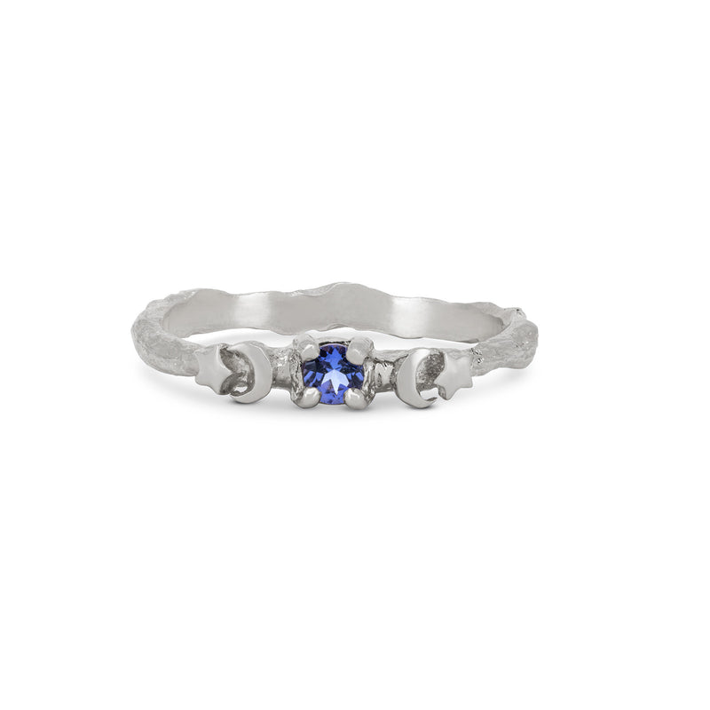 Front view of the Sun, Moon & Stars Tanzanite Ring in 14k white gold, featuring a round tanzanite stone flanked by sun, moon, and star motifs on a twig band.