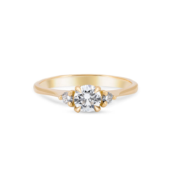 Front view of the You, Me & Magic Round Cut Three Stone Engagement Ring in 14k solid gold, featuring a 0.5ct central round cut diamond flanked by two smaller stones on a polished band.