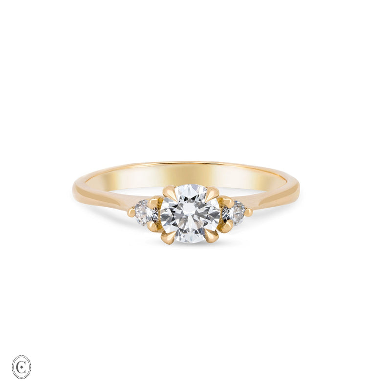 Front view of the You, Me & Magic Round Cut Three Stone Engagement Ring in 14k solid gold, featuring a 0.5ct central round cut diamond flanked by two smaller stones on a polished band.