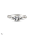 Front view of the You, Me & Magic Round Cut Three Stone Engagement Ring in 14k white gold, featuring a 0.5ct central round cut diamond flanked by two smaller stones on a polished band.
