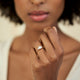 Close-up of a hand wearing the Heart's Light Three Stone Diamond Engagement Ring in 14k solid gold.